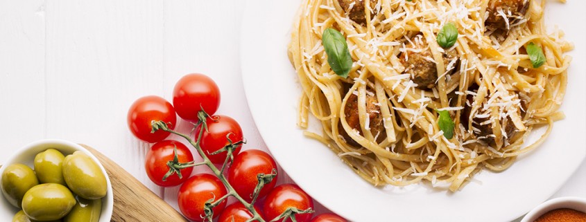 Tasty appetizing bolognese pasta penne with sauce and parmesan. Served on plate on grey background. Closeup.